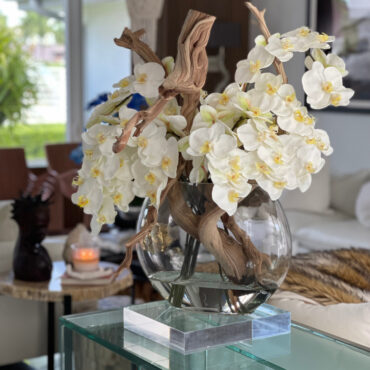 Vaso Moon de  com orquídeas brancas.