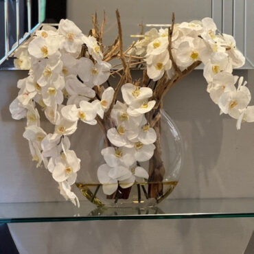 Vaso Moon de  com orquídeas brancas.