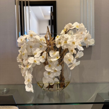 Vaso Moon de  com orquídeas brancas.