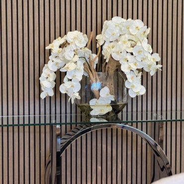 Vaso Moon de  com orquídeas brancas.
