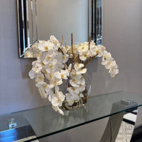 Vaso Moon de  com orquídeas brancas.